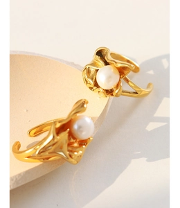 Detail of gold-plated lava ring with white pearl on organic textured metal band