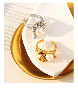 Detail of adjustable lava-style gold and silver rings with round white pearls