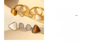 Detailed view of gold plated titanium rings featuring tiger eye stone and shell insets