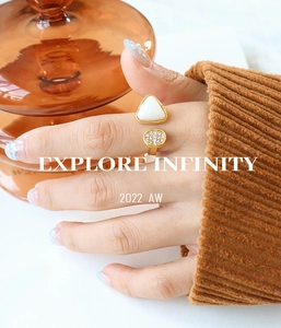 Detail of gold open ring featuring triangular mother of pearl and paved crystal accents
