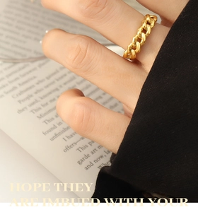 Detailed shot of a golden Cuban link chain ring worn for a minimalist fashion style