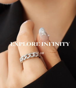 Macro detail of silver Cuban link chain ring on index finger with sleek polished finish