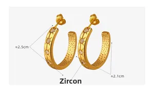 Macro detail of gold C-shaped earrings with zircon star engraving and 2.5cm height