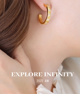Close-up of 18K gold starburst engraved C-shaped earrings with inlaid zircon on ear