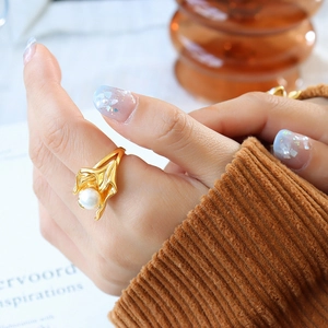 Irregular gold lava flower ring with pearl inlay worn by a model in a retro style