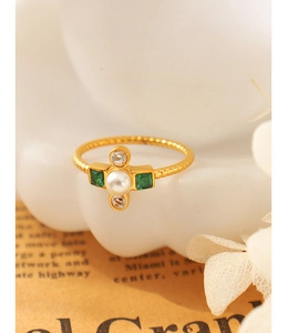 Detail of baroque pearl and emerald green gemstone cross ring with twisted gold band