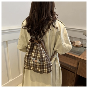 Detailed back view of a retro brown plaid drawstring backpack with dog embroidery