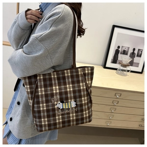 Detail of checkered tote bag with brown plaid pattern and cute dachshund embroidery