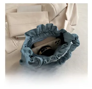 Internal view of blue denim drawstring bucket bag showing storage capacity for essentials