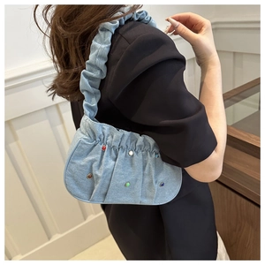 Detail of light blue denim cloud bag with colorful beads and ruffled shoulder strap