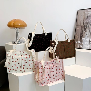 Corduroy strawberry tote bags in four colors with adjustable shoulder straps and top handles