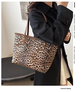 Detail of leopard print tote bag featuring brown leather straps and gold rivet accents