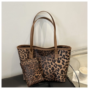 Leopard print tote bag set with matching zipper pouch on a black leather surface