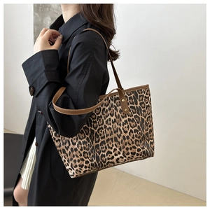 Lifestyle shot of large leopard print tote bag with brown straps on model shoulder