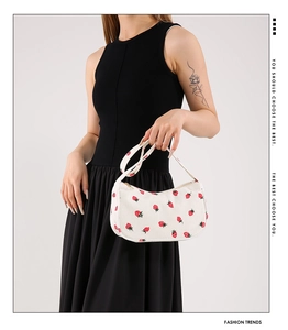 Détail du sac à bandoulière en velours côtelé blanc avec imprimé fraise et fermeture éclair
