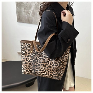 Detail of leopard print tote bag with brown straps and gold hardware on female model