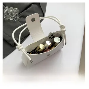Interior view showing capacity of the white shoulder bag with phone and perfume