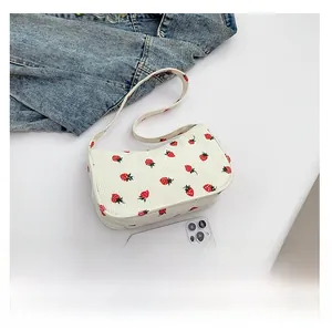 Détail du sac sous le bras en velours côtelé blanc cassé avec imprimés fraises