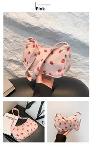 Gros plan détaillé d'un sac à main en velours côtelé avec imprimé fraise et bandoulière