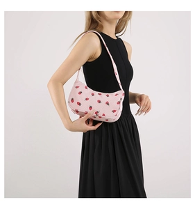Sac baguette en velours rose avec imprimé fraises porté par un mannequin en robe