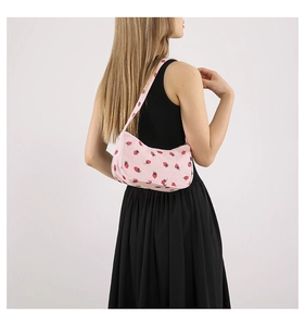 Détail de la texture du sac porté épaule en velours côtelé rose avec motif fraise
