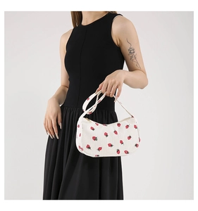 Détail du sac bandoulière en velours blanc avec imprimé fraise et fermeture éclair dorée
