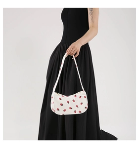 Détail du sac croissant en velours blanc avec motif fraise et fermeture éclair dorée