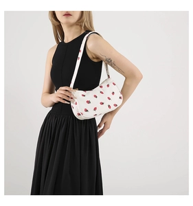 Détail du sac à bandoulière en velours côtelé blanc avec motif fraise et texture striée