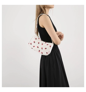 Détail du sac d'épaule blanc en velours côtelé avec imprimé fraise et zip doré brillant