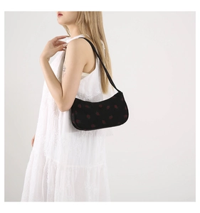 Détail du sac à épaule en velours côtelé noir avec broderie fraise rouge