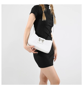 Detail of white leather underarm bag featuring a large silver metallic butterfly buckle