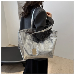 Detailed view of silver crocodile pattern tote bag with metallic sheen on shoulder