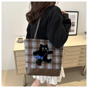 Détail du sac fourre-tout vintage à carreaux avec motif chat noir et bandoulière en cuir