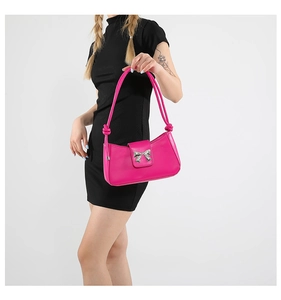Detail of pink shoulder bag with silver butterfly hardware and knotted strap accents