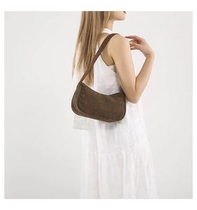 Détail du sac hobo en velours côtelé marron à motif fraises porté par un mannequin