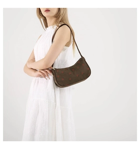 Détail du sac croissant en velours côtelé marron foncé avec motif fraise et bandoulière