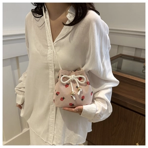 Pink corduroy strawberry bucket bag with drawstring closure and crossbody strap