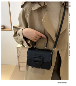 Minimalist black faux leather crossbody bag with iconic large buckle and thin strap