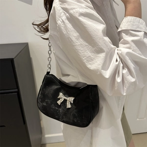 Black velvet baguette shoulder bag with silver bow accent and metal chain strap