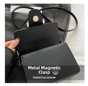 Détail de la fermeture magnétique en métal d'un petit sac à bandoulière noir