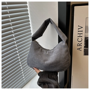 Macro shot of grey corduroy shoulder bag showing vertical ribbed texture and soft handle