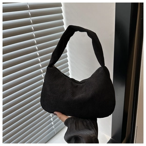 Detailed view of the black corduroy texture and zipper closure on the hobo armpit bag