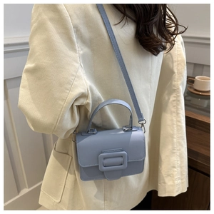 Sac à main bleu clair porté avec un blazer en velours beige pour un style élégant d'automne