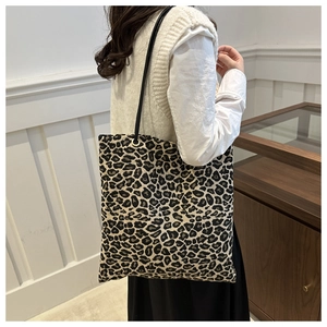 Close-up of leopard print canvas tote bag with slim black shoulder straps and spacious design