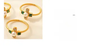 Detailed shot of gold-plated twisted rings with green zircon and pearl cross design