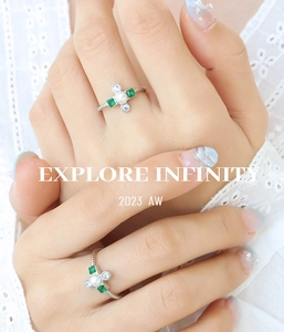 Detail of gold titanium ring with center pearl and green crystal floral setting