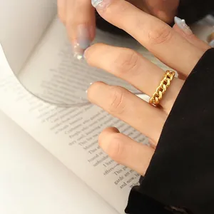 Minimalist gold Cuban chain ring for women styled on a vintage book for a trendy look