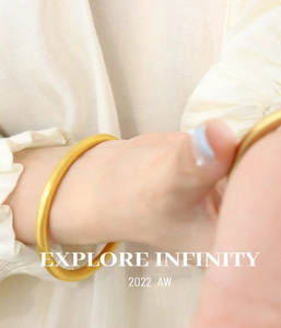 Close-up of minimalist golden matte bangle with a smooth round geometric design