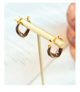Nahaufnahme der Vintage Gold V-Ohrringe mit braunem Emaille auf einem Schmuckständer