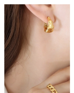 Détail de boucles d'oreilles en C style bambou plaqué or et bague texturée assortie sur modèle